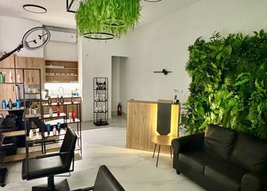 Εσωτερικός χώρος του Gspot Hair Studio, Ilioupoli, GR με πράσινο τοίχο και μοντέρνα διακόσμηση.