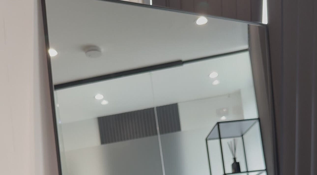 Elegant interior at Bodyaidbham in Birmingham, England featuring a large mirror and modern decor.