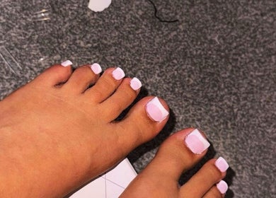 Pastel pink pedicure at Glosseditbychelsie, Clitheroe, England, GB; stylish toe nails on a textured surface.