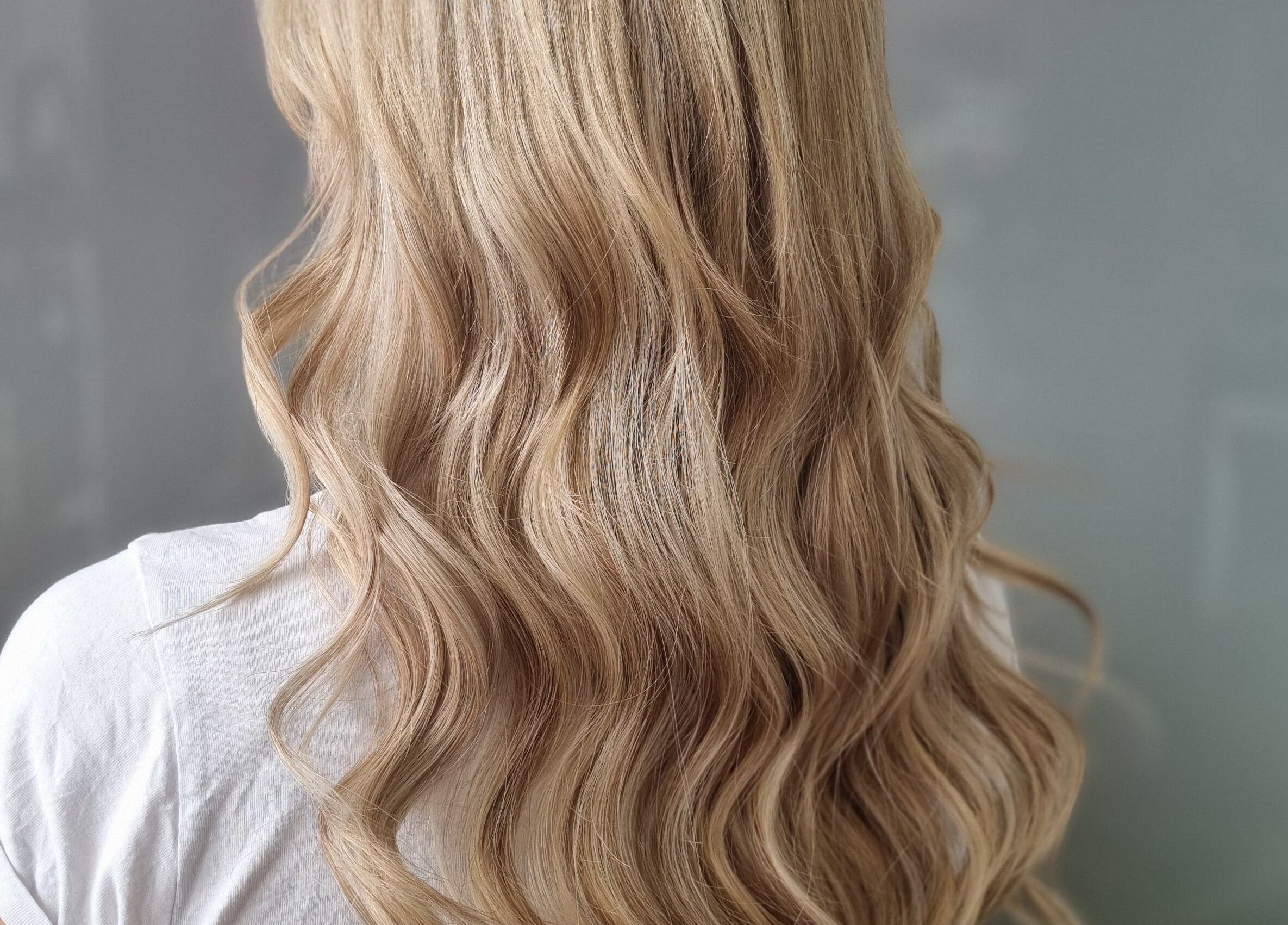 Blonde wavy hair styled at The Aries Chair Salon, Melbourne, Victoria, AU showcasing elegant beauty.