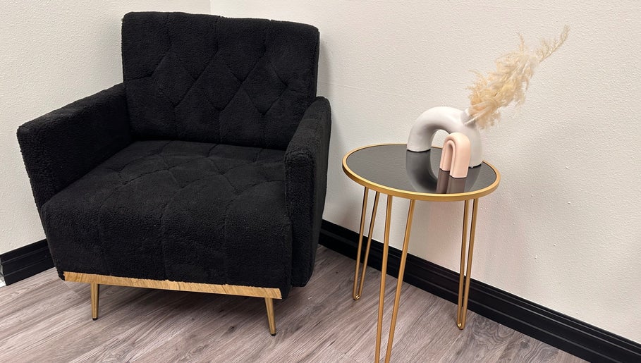 Cozy black chair and stylish table at Sabrina Beauty, Lincoln Park, Michigan, US. Modern, inviting ambiance.