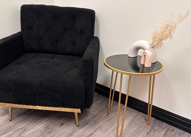 Cozy black chair and stylish table at Sabrina Beauty, Lincoln Park, Michigan, US. Modern, inviting ambiance.