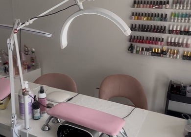 Modern nail salon interior at Leannasnailart, Dagenham, England, GB with pink accents and various nail polishes.