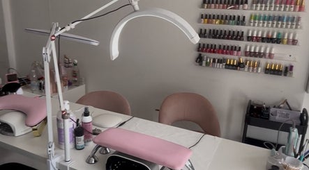 Modern nail salon interior at Leannasnailart, Dagenham, England, GB with pink accents and various nail polishes.