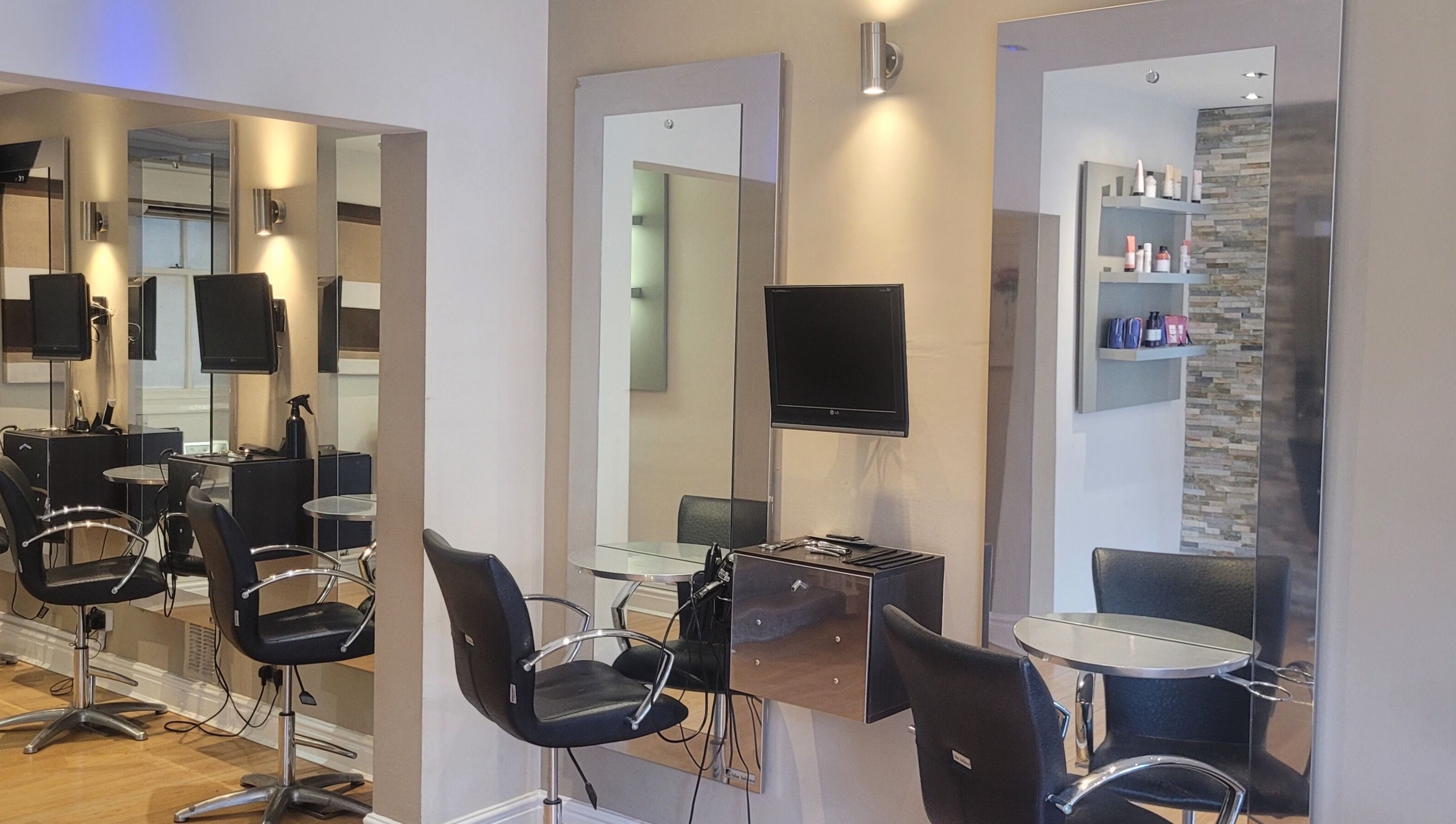 Modern salon chairs and mirrors at Greg Malloy Hairdressing, Penrith, England, GB, reflecting a stylish interior.