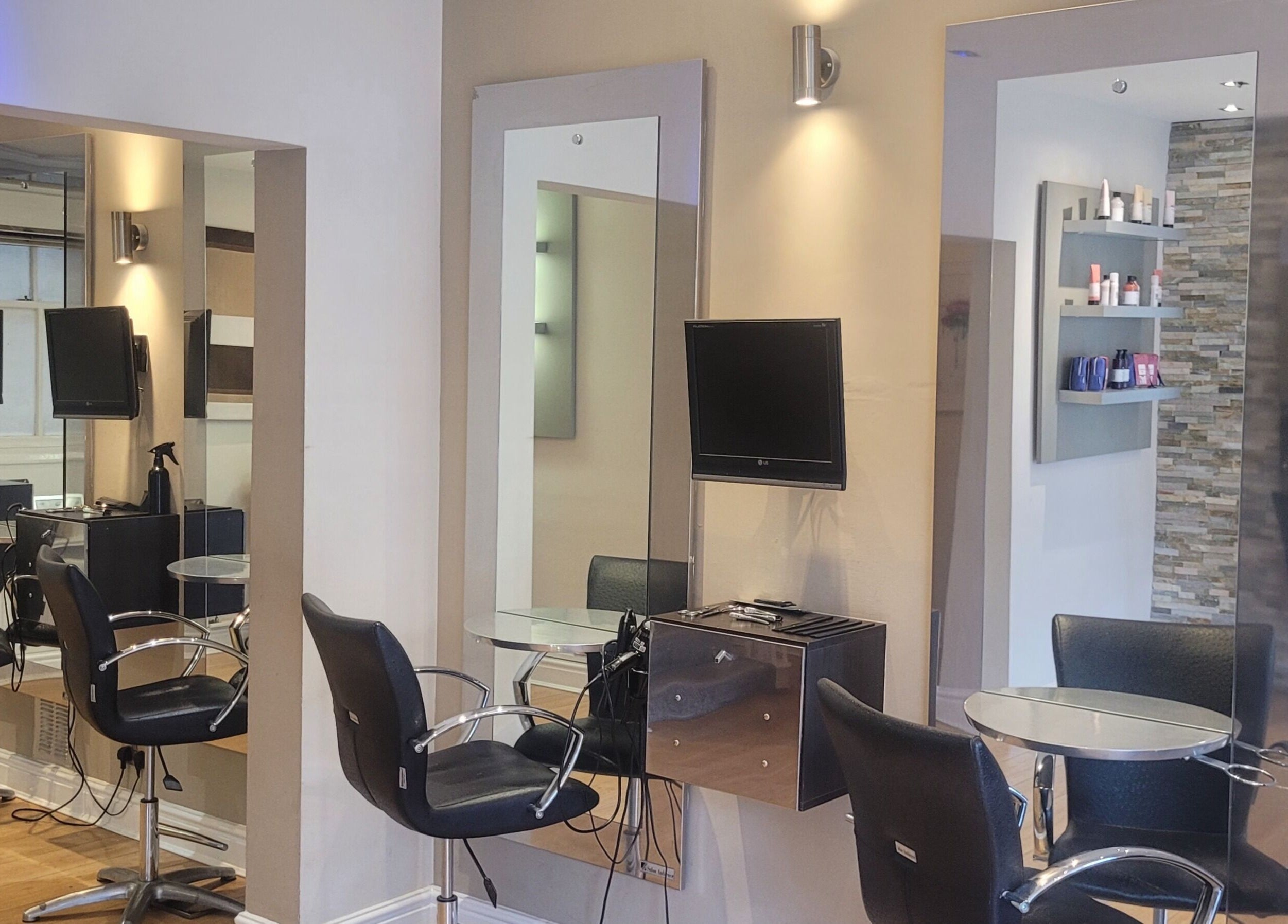 Modern salon chairs and mirrors at Greg Malloy Hairdressing, Penrith, England, GB, reflecting a stylish interior.