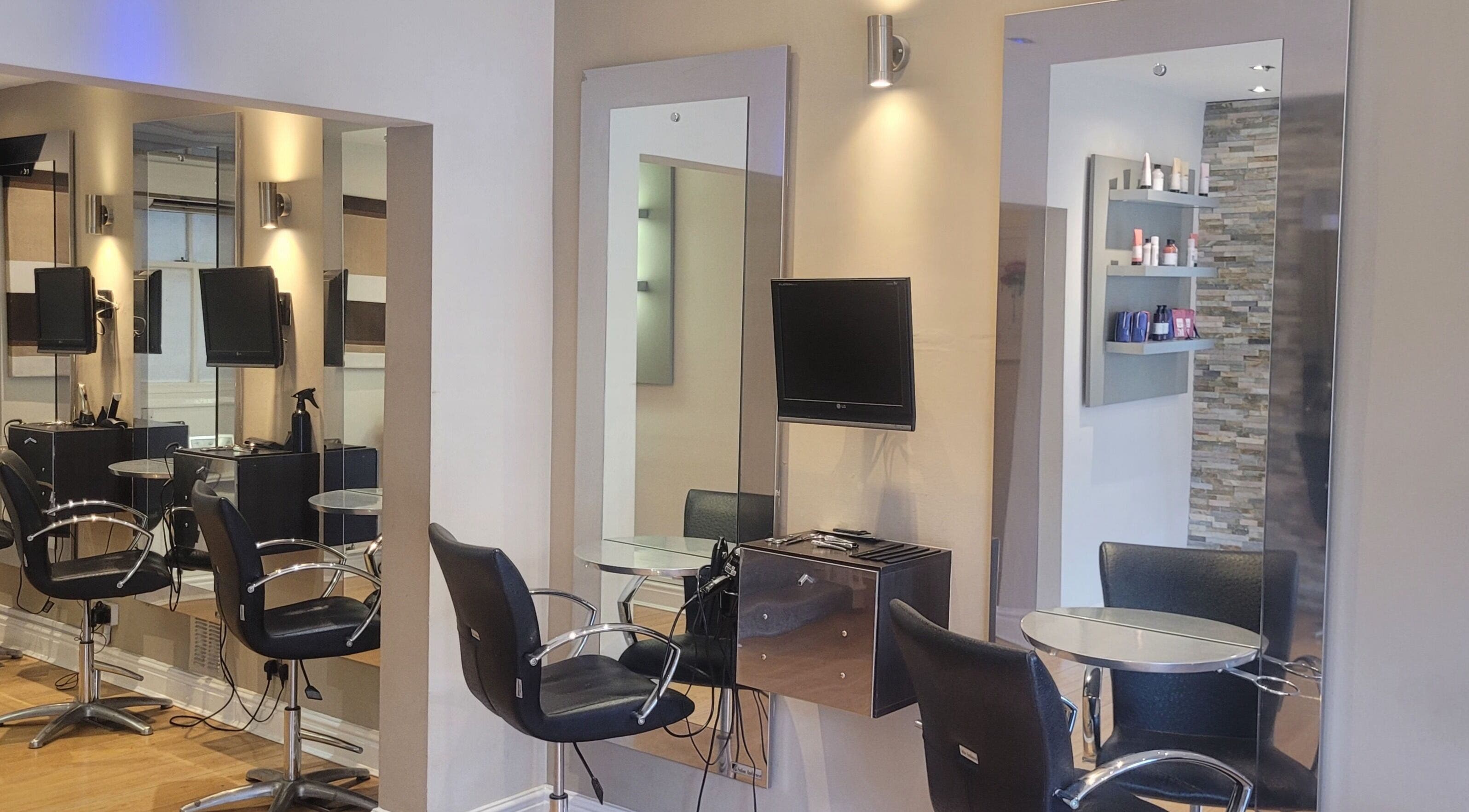 Modern salon chairs and mirrors at Greg Malloy Hairdressing, Penrith, England, GB, reflecting a stylish interior.