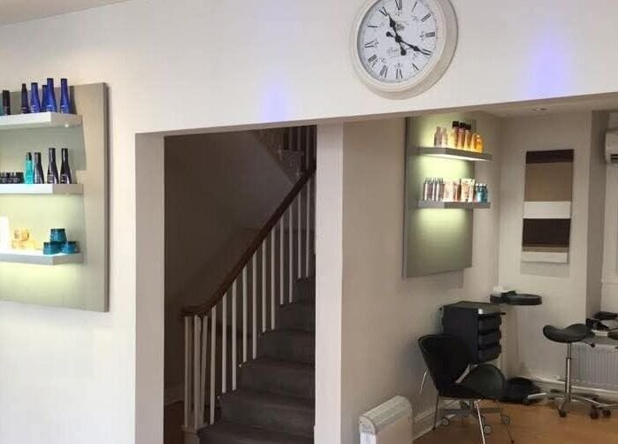 Interior of Greg Malloy Hairdressing in Penrith, England, GB, showcasing stylish shelving and seating area.