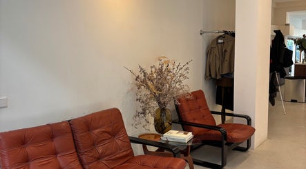 Cozy seating area at Pascale Marie Hair in Amsterdam, Noord-Holland, NL with stylish leather chairs and decor.