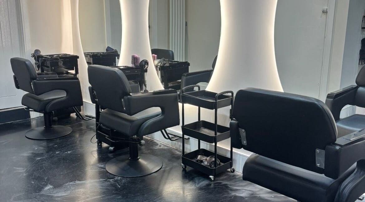 Modern salon station at Jess Ram Hair, Leicester, England, GB with sleek chairs and illuminated mirrors.
