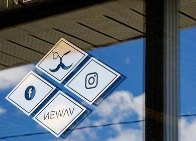 Newav Saint-Hubert signage on window in Longueuil, Québec, CA reflecting sky.