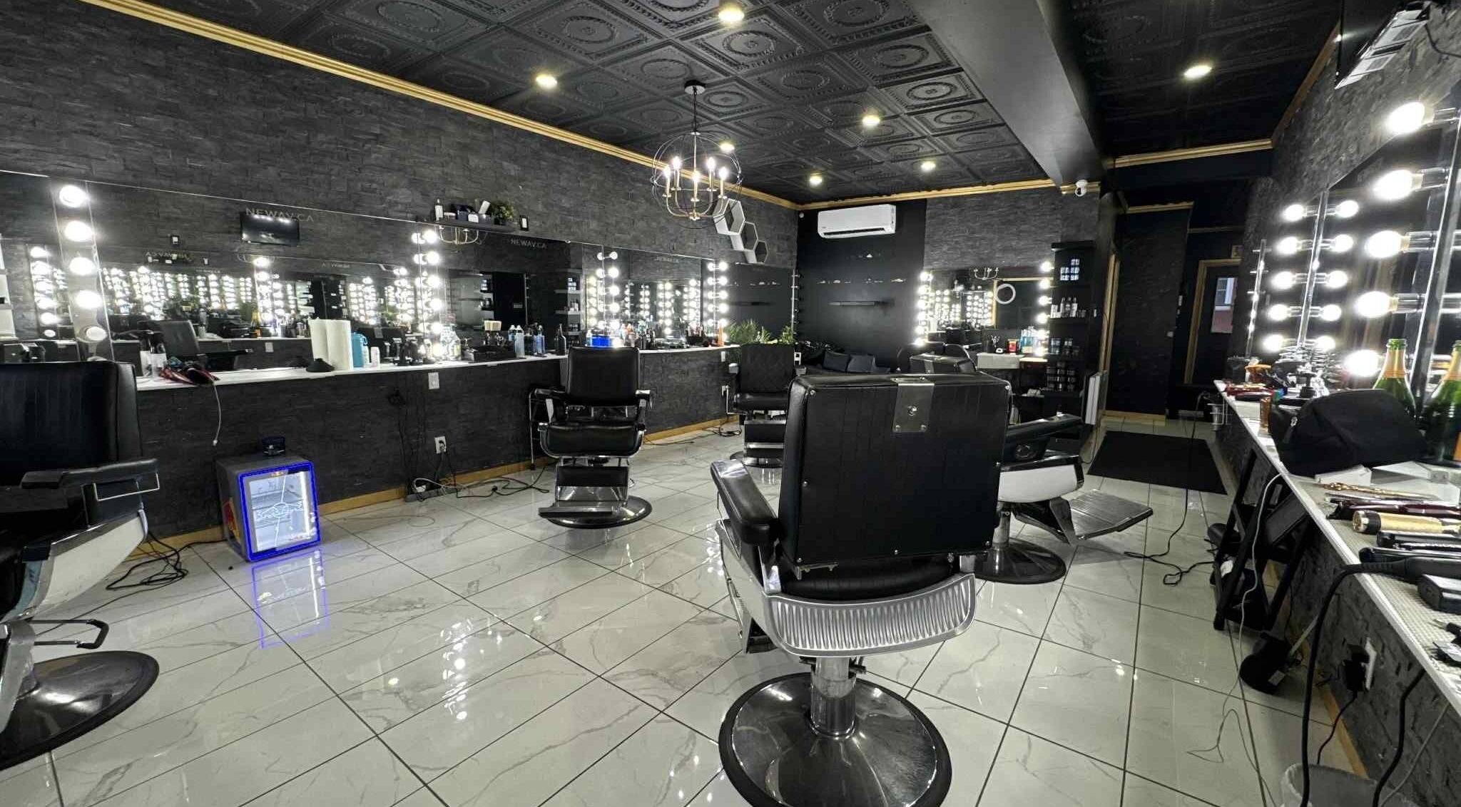 Chic interior of Newav Saint-Hubert salon in Longueuil, Québec, CA with stylish chairs and illuminated mirrors.