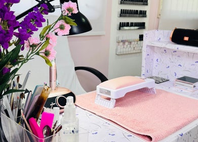 Elegant Touch By Lia's Nails manicure setup with pink mat and flowers in Willemstad, Curaçao, CW.