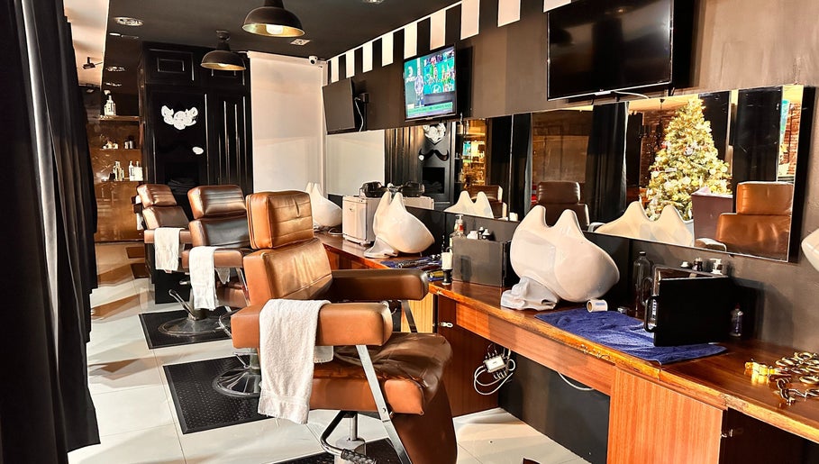Interior moderno de Kings Barber Shop en Quito, Pichincha, EC, con sillas de cuero y espejos amplios.