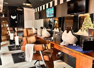 Interior moderno de Kings Barber Shop en Quito, Pichincha, EC, con sillas de cuero y espejos amplios.