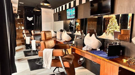 Interior moderno de Kings Barber Shop en Quito, Pichincha, EC, con sillas de cuero y espejos amplios.