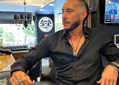 Interior de Kings Barber Shop, Quito, Pichincha, EC, con un hombre elegante en el mostrador.