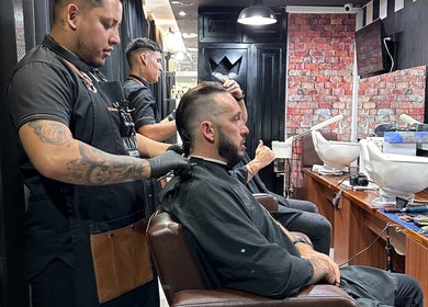 Barbero trabajando en corte de cabello en Kings Barber Shop, Quito, Pichincha, EC.