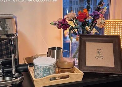 Elegant coffee setup at JasNail Studio, Halifax, Nova Scotia, CA next to a vibrant floral display.