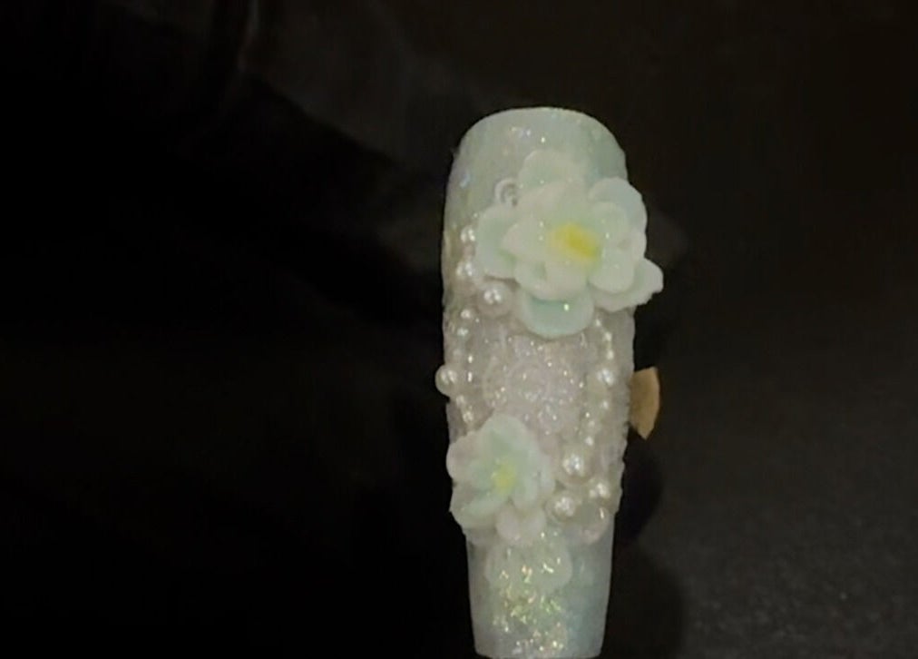 Intricate flower nail art from JasNail Studio, Halifax, Nova Scotia, CA showcasing delicate blooms and pearls.