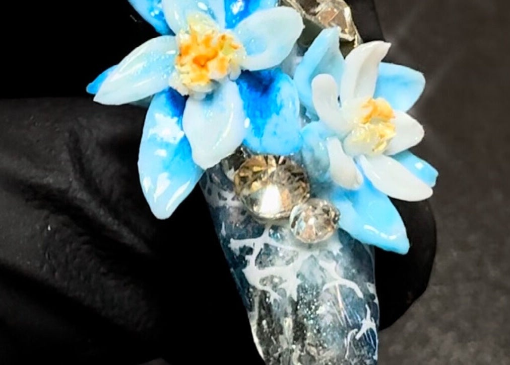 Intricate floral nail art with blue flowers at JasNail Studio in Halifax, Nova Scotia, CA.