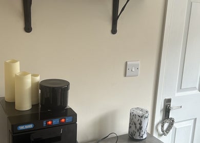 Warm and inviting treatment room corner at The Retreat at Salon Nine, Stone, England, GB with candles and towel warmer.