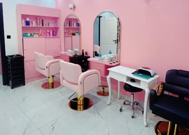 Elegant pink and white interior of Flicks Glam Ladies Salon in Dubai, AE with modern styling stations.
