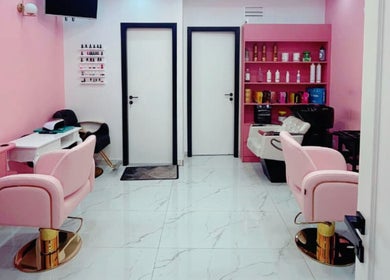 Stylish interior of Flicks Glam Ladies Salon in Dubai, AE with elegant pink chairs and modern decor.
