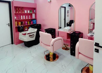 Chic pink salon interior at Flicks Glam Ladies Salon in Dubai, AE with stylish chairs and beauty stations.