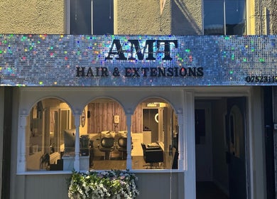 Amt Hair & Extensions shopfront with illuminated sign in Ballymena, Northern Ireland, GB.