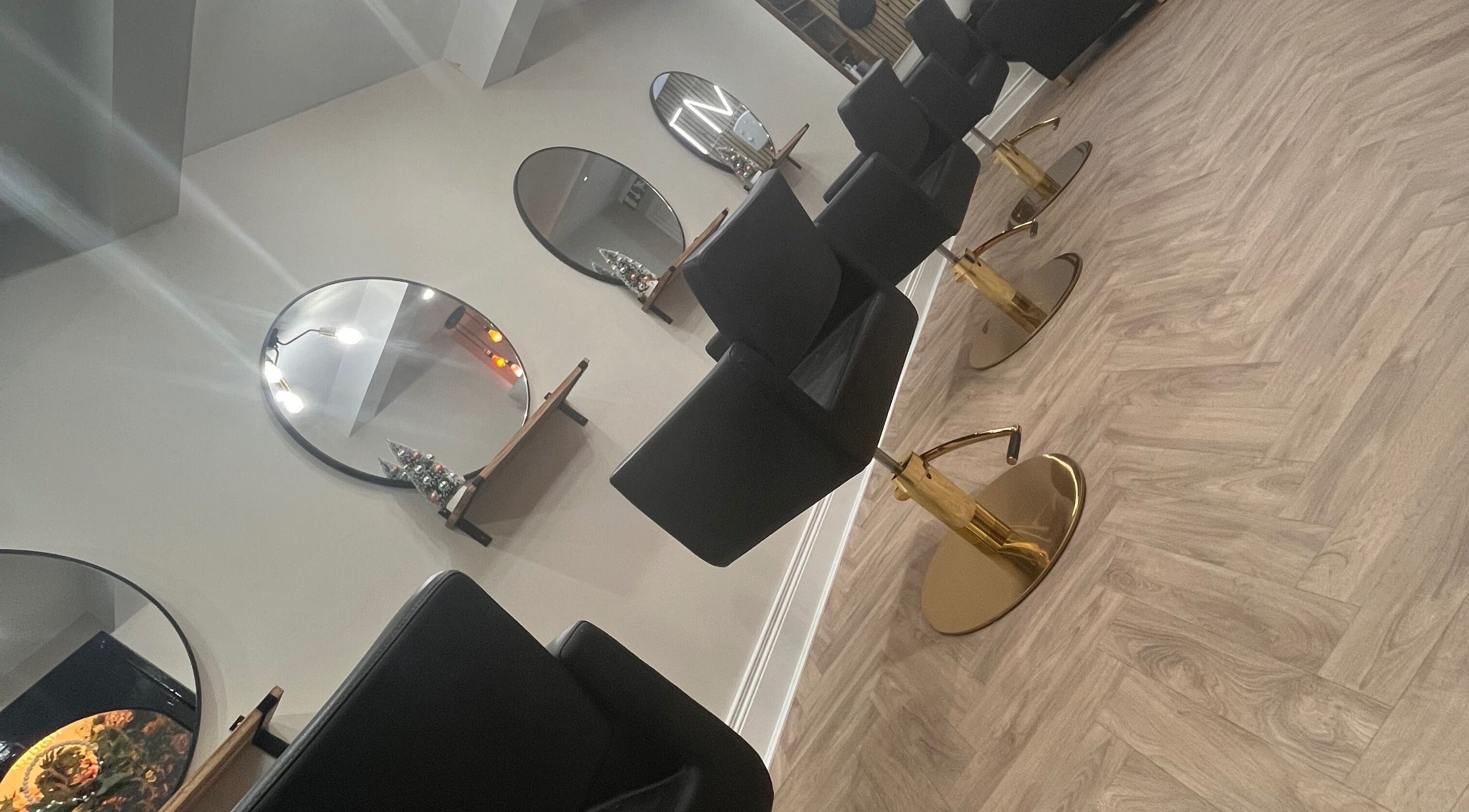 Chic salon interior with mirrors and chairs at Amt Hair & Extensions, Ballymena, Northern Ireland, GB.
