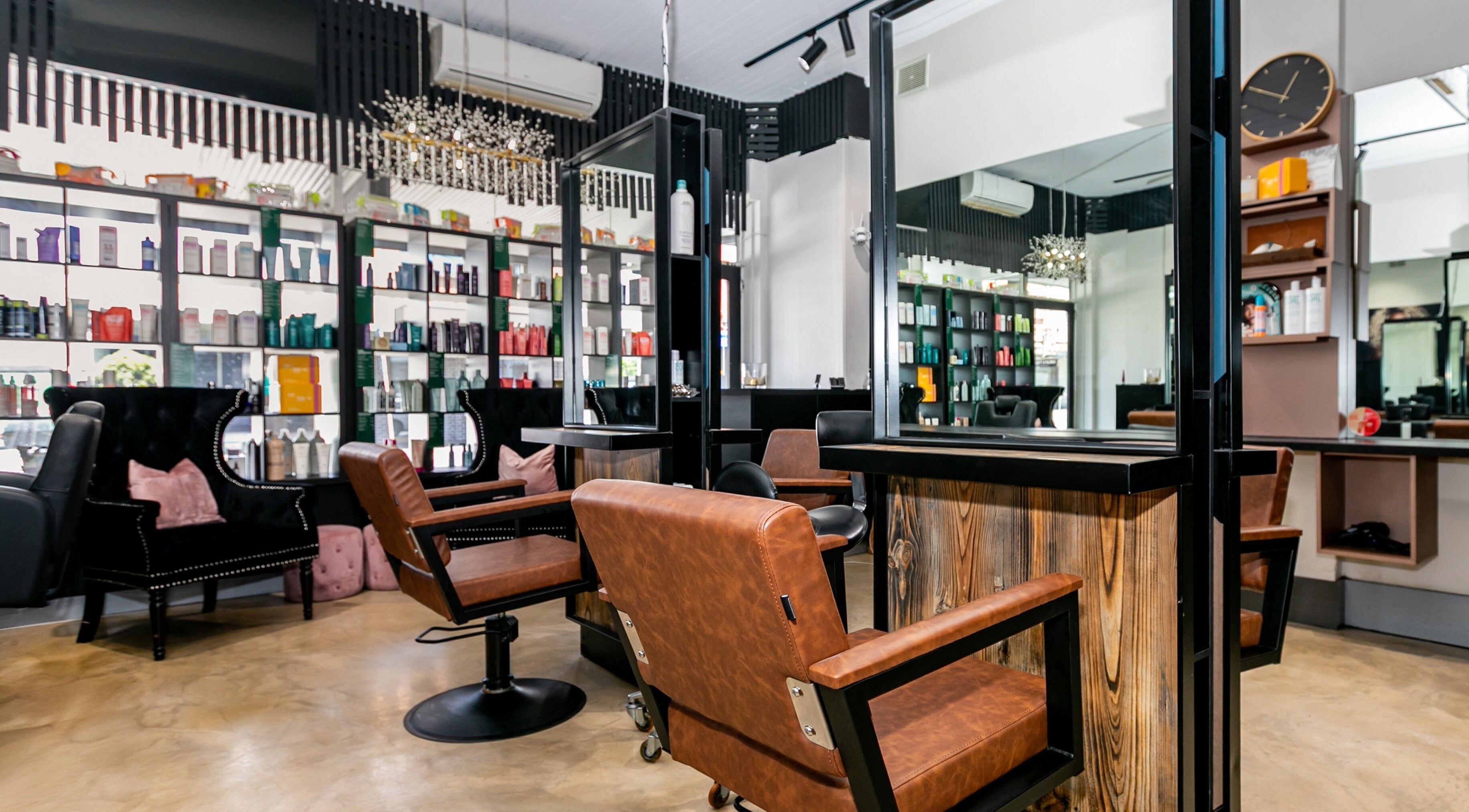 Interior view of Lotus Hair Salon in Camberwell, Victoria, featuring stylish chairs and product shelves.