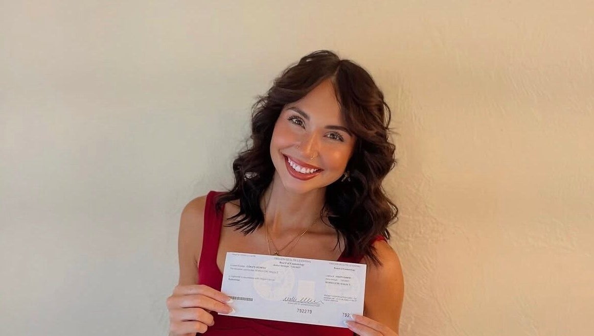 Smiling person showcasing certificate at GuchiGlowUp, Eugene, Oregon, US, exemplifying beauty and wellness.