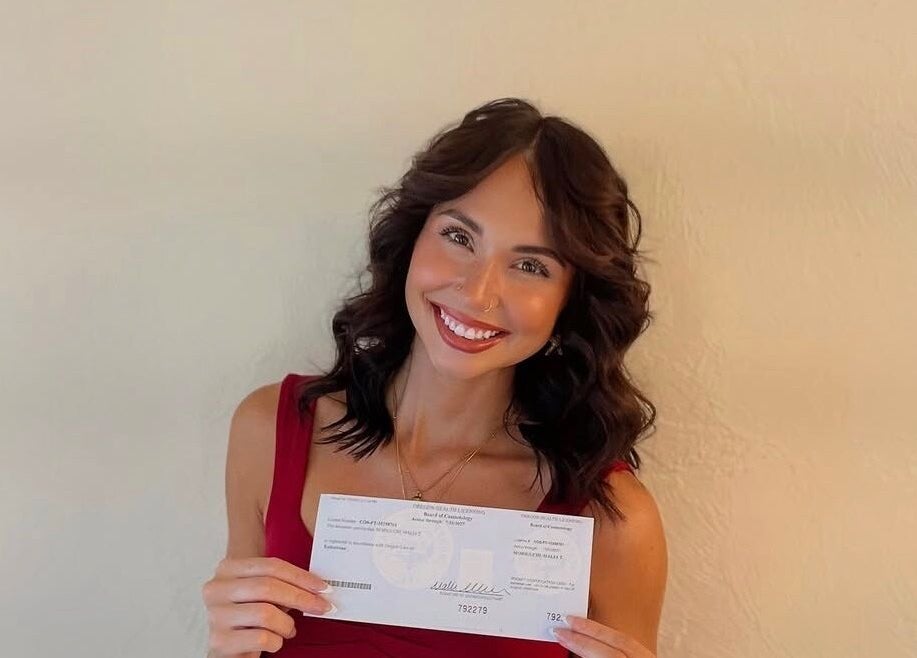 Smiling person showcasing certificate at GuchiGlowUp, Eugene, Oregon, US, exemplifying beauty and wellness.