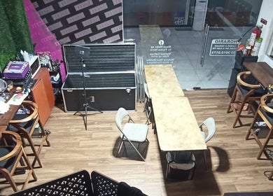Makeup studio setup at Maya Make Up, Zapopan, Jalisco, MX, featuring stylish wooden chairs and makeup stations.