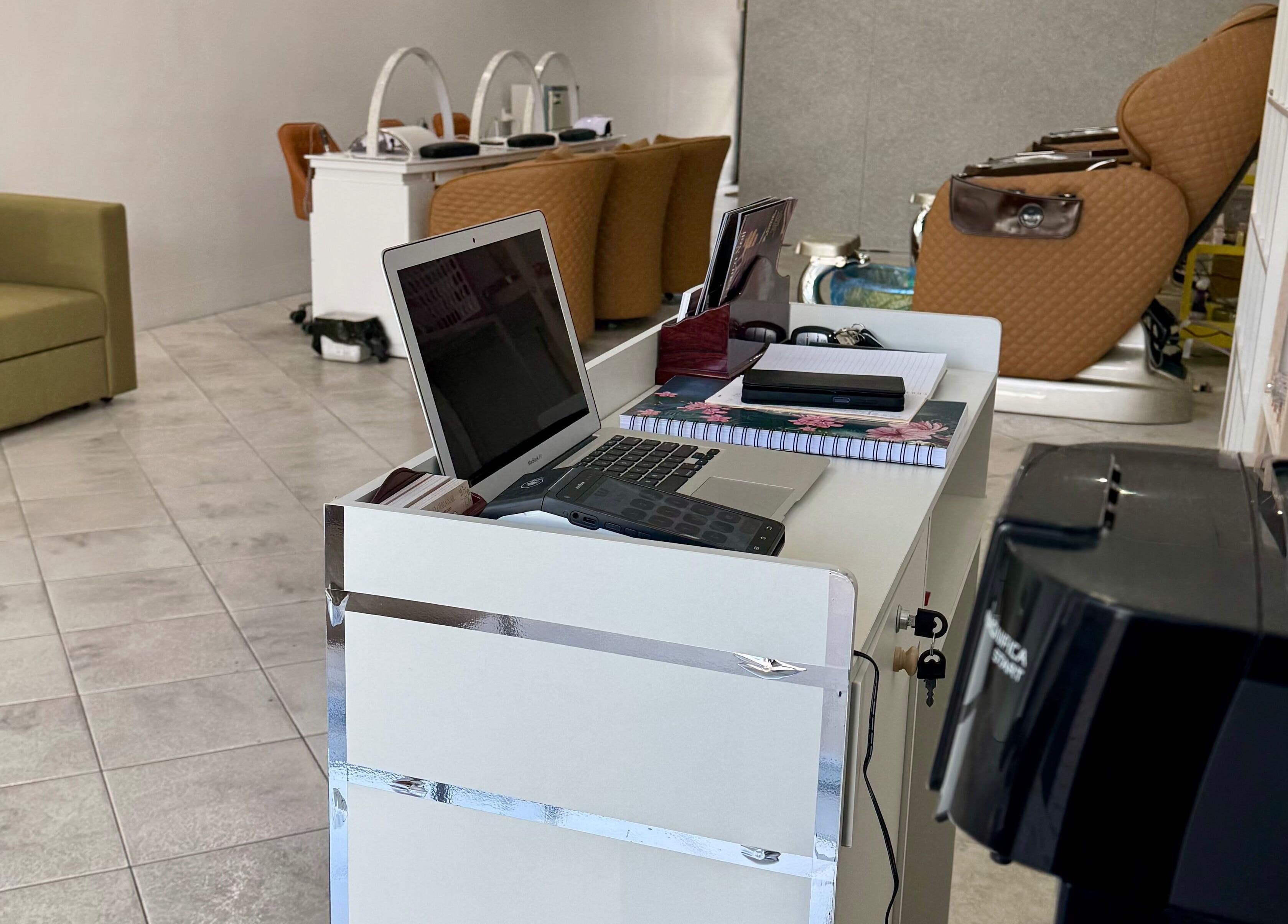 Reception area at Eloura Nail, Plympton, South Australia, AU, with a laptop and comfortable seating.