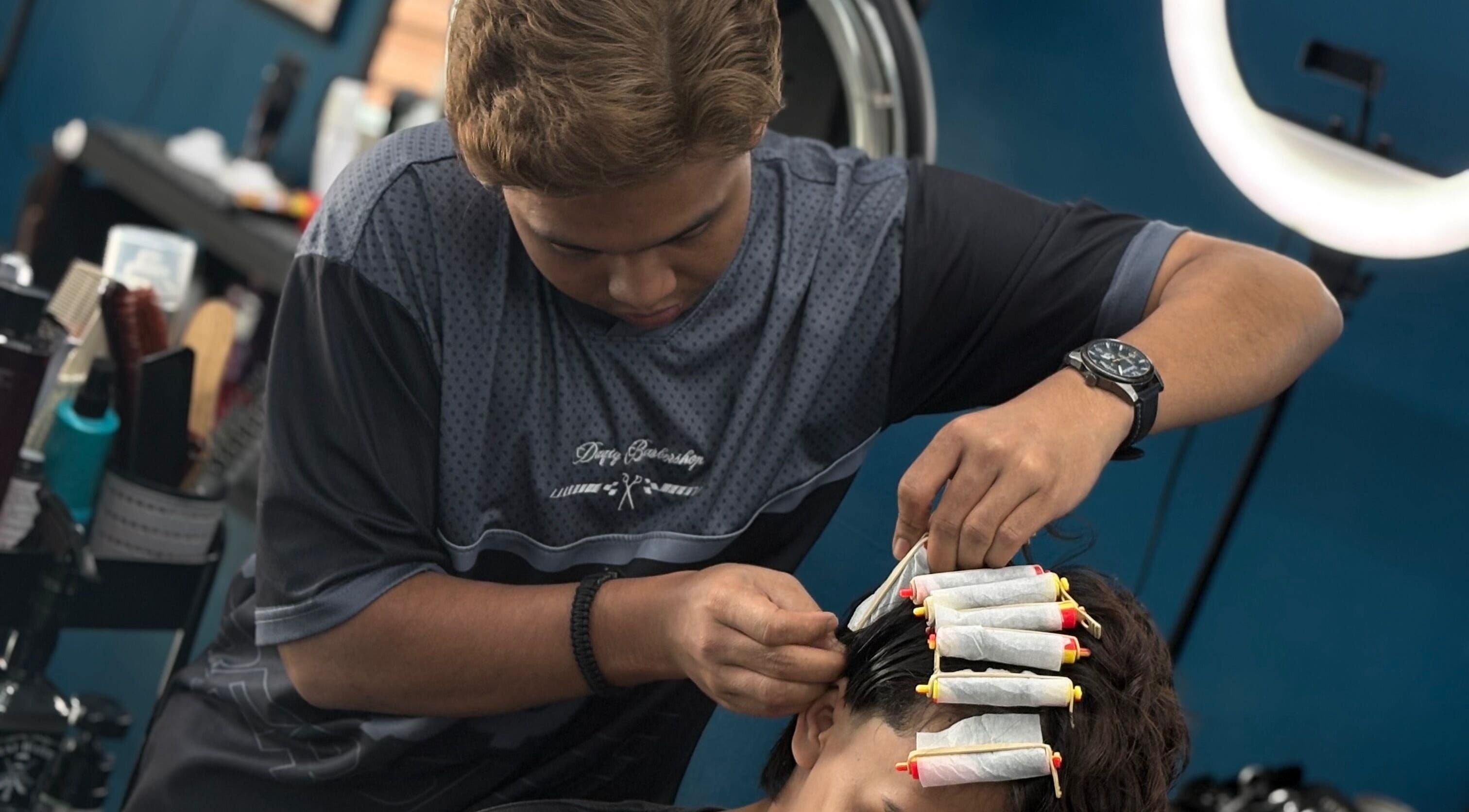 Barber giving a perm at Daqiq Barbershop, Simpang Empat, Kedah, MY, showcasing professional styling.