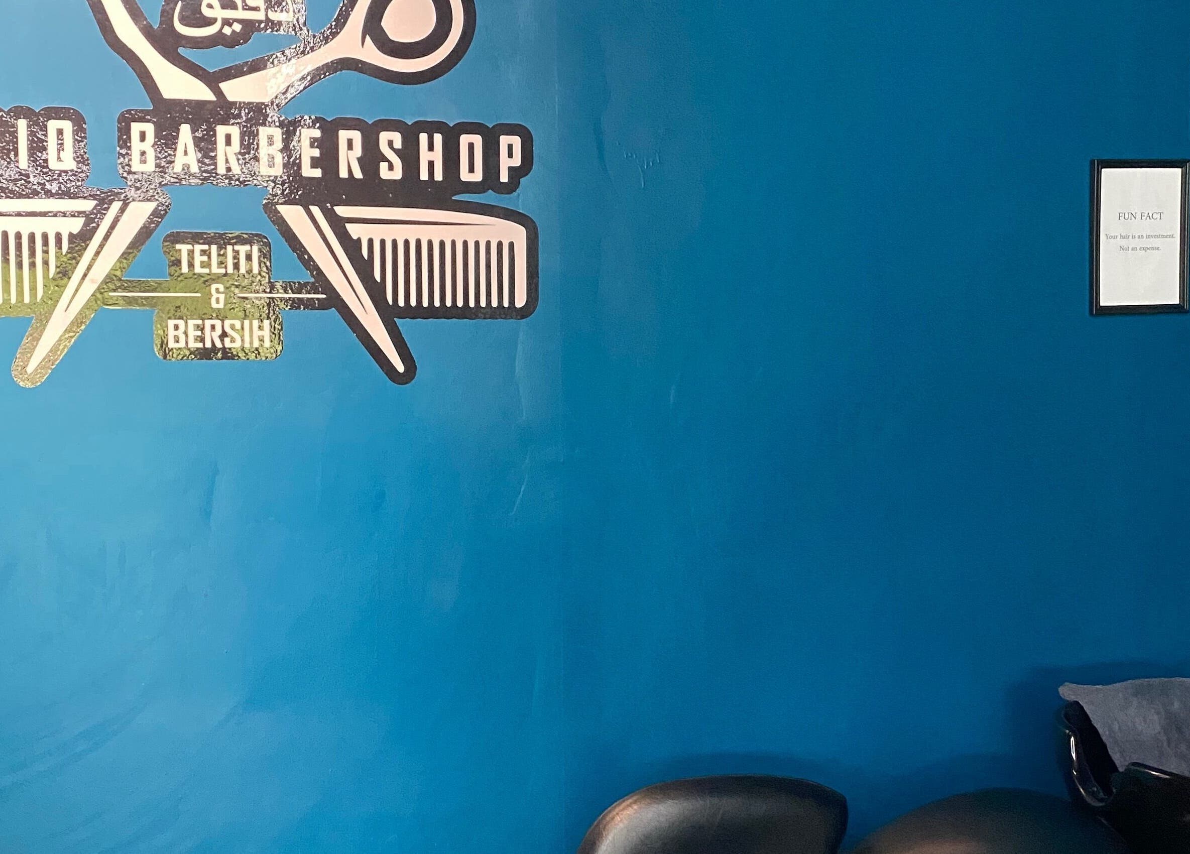 Daqiq Barbershop's vibrant blue wall with logo at Simpang Empat, Kedah, MY. Stylish ambiance.