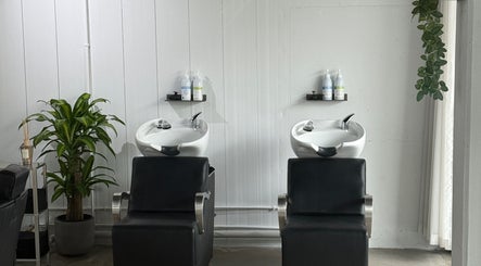 Modern hair washing stations at STUDIO.M in Camperdown, New South Wales, AU with stylish black chairs.