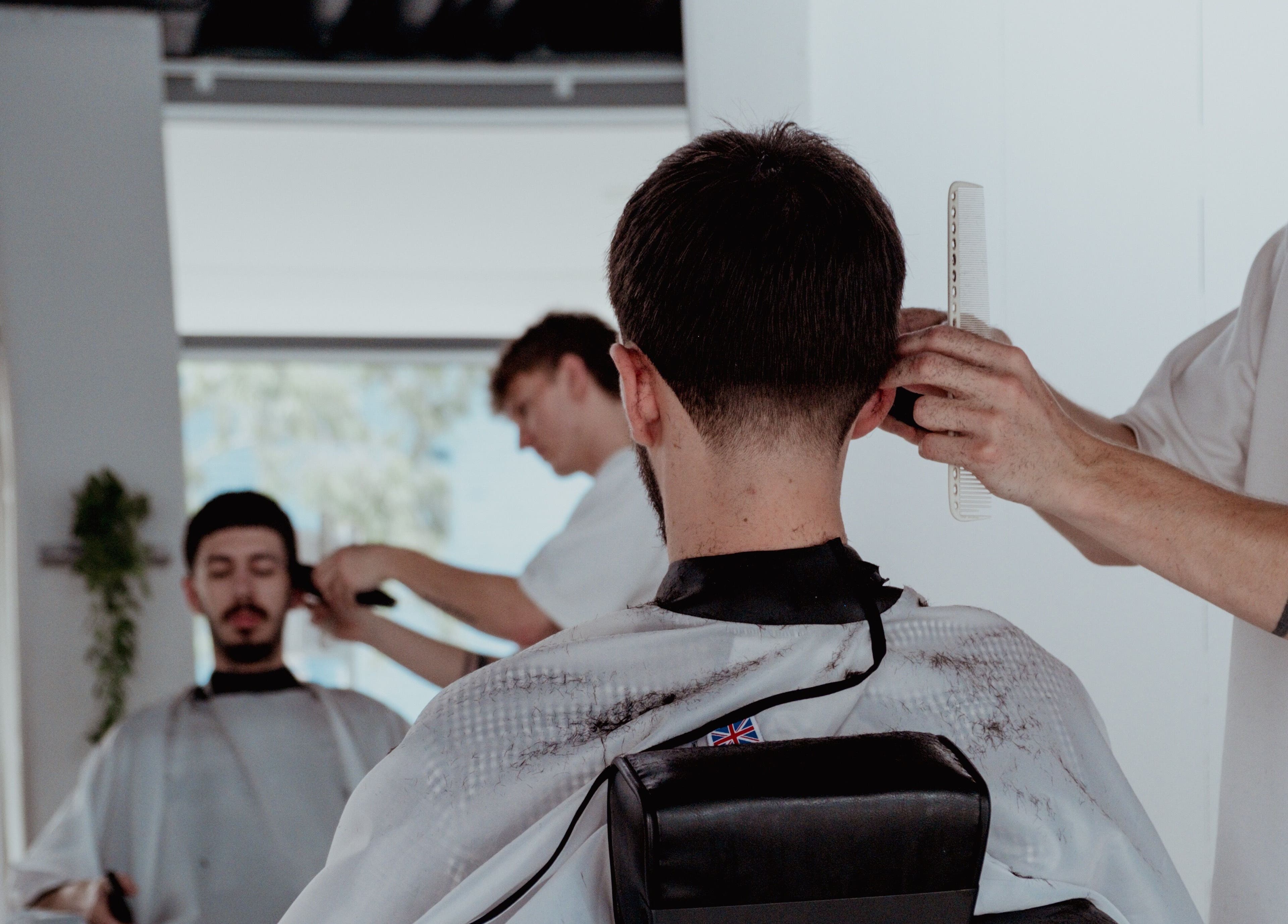 Hair stylist working at Studio.M in Camperdown, New South Wales, AU, providing a precise haircut.