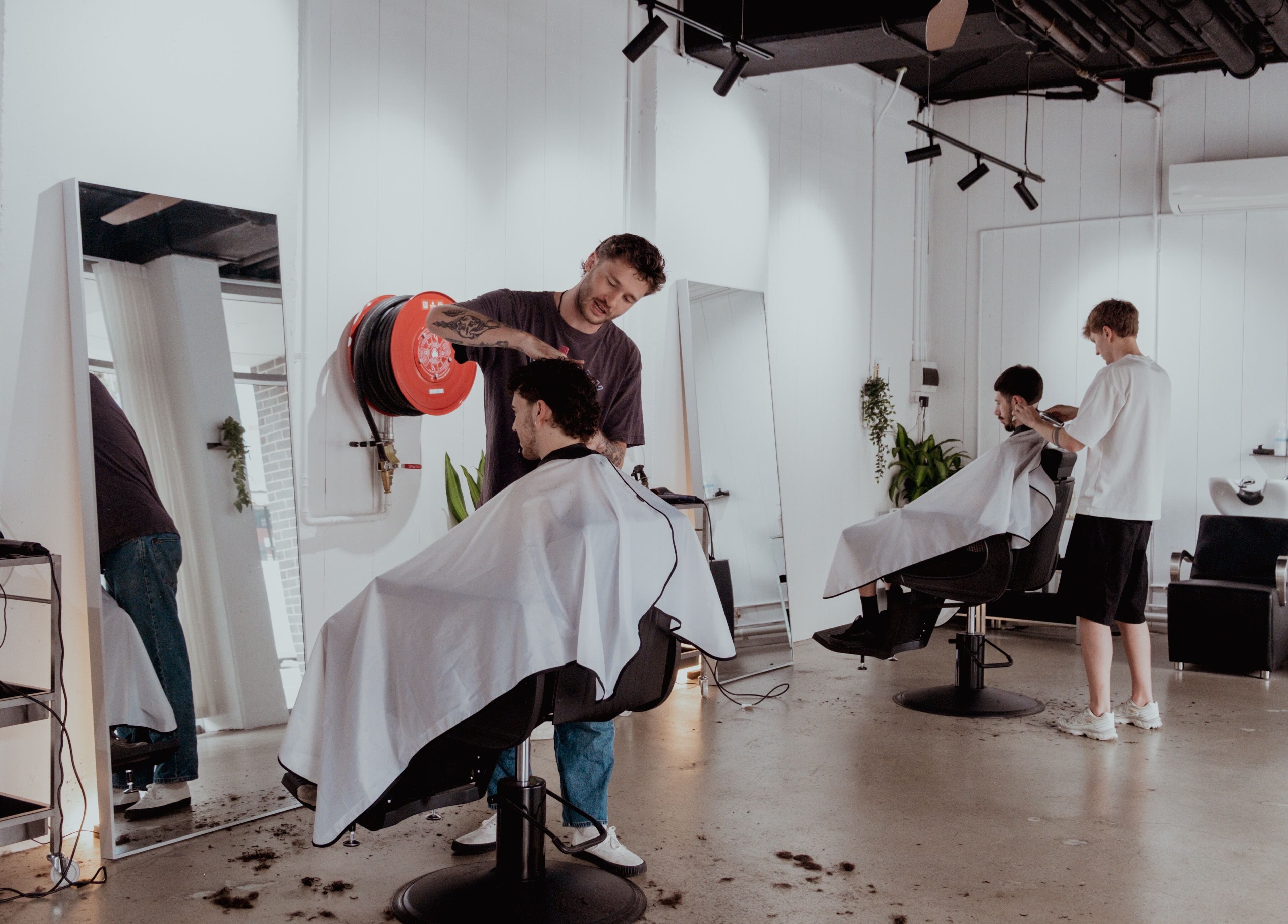 Stylish haircuts at Studio.M, Camperdown, New South Wales, AU. Modern salon interior with attentive barbers.