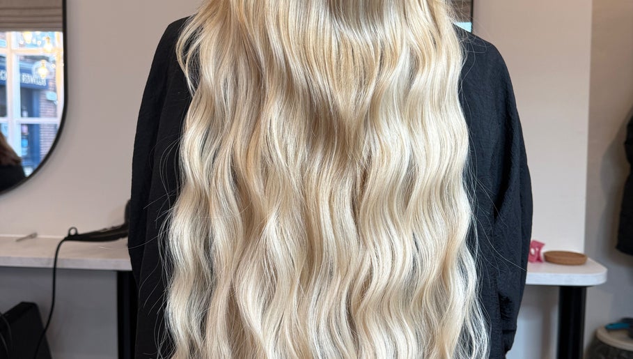Long, wavy blonde hair styled beautifully at Beau Hair, Gilberdyke, England, GB mirror reflection visible.