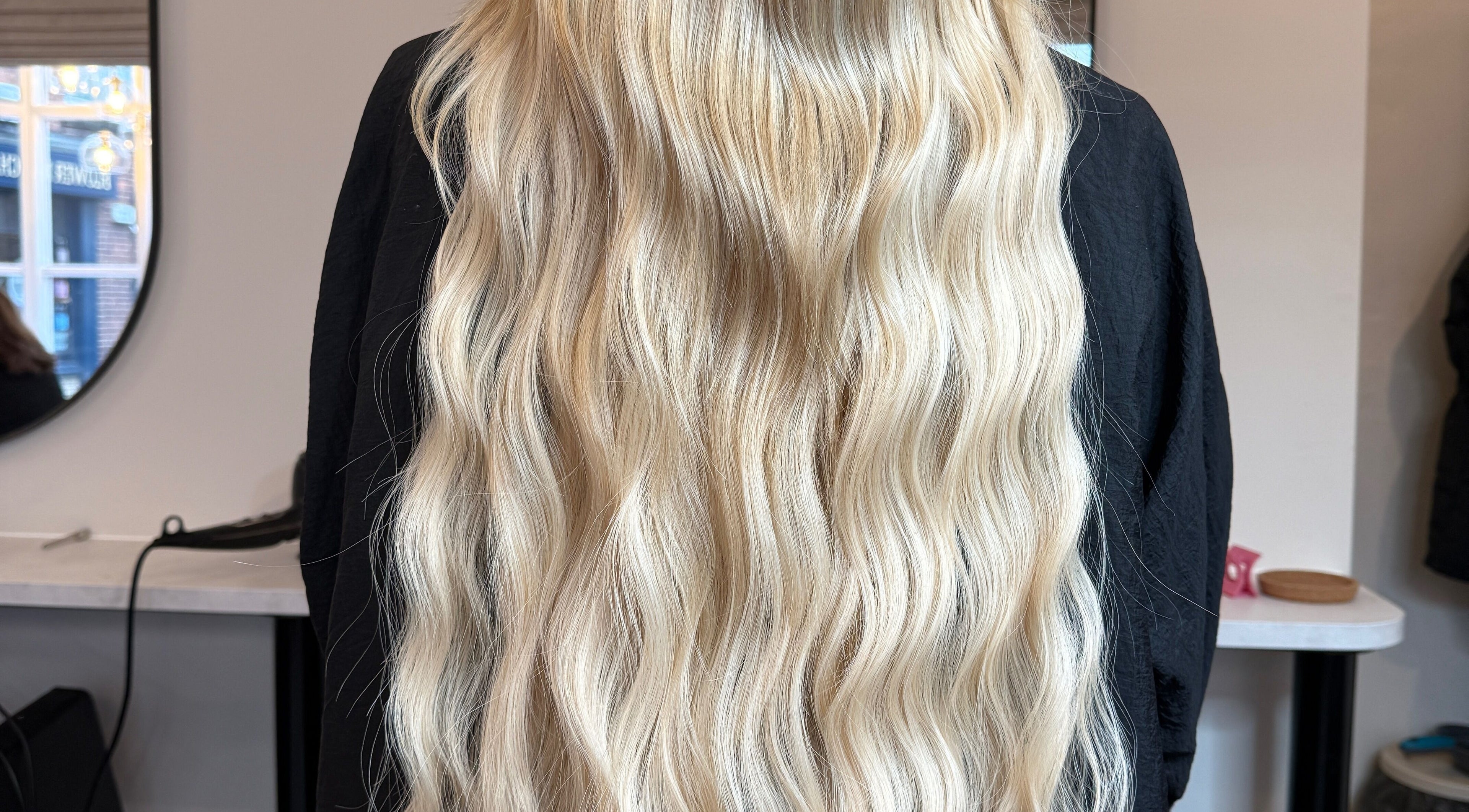 Long, wavy blonde hair styled beautifully at Beau Hair, Gilberdyke, England, GB mirror reflection visible.