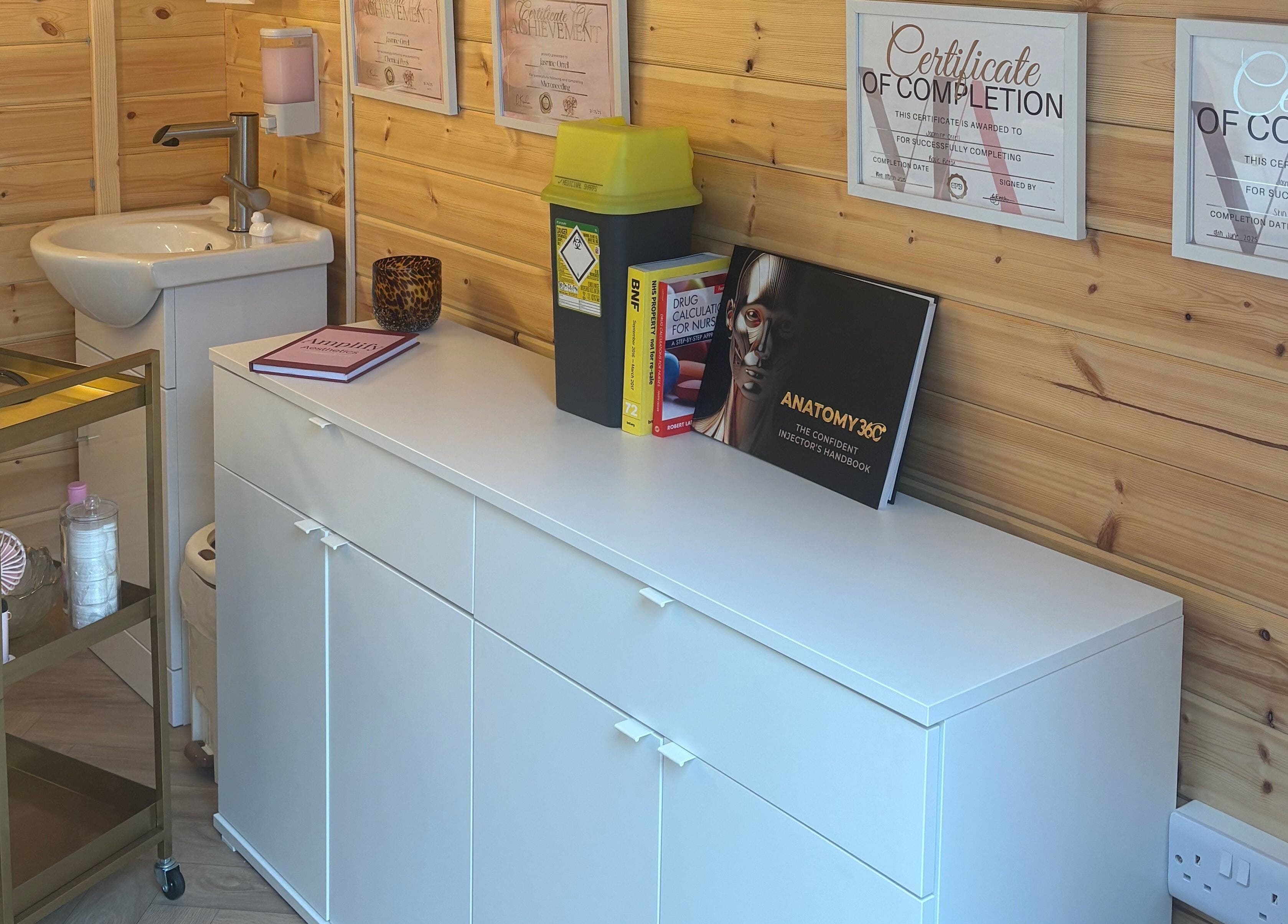 Amplify Aesthetics treatment room with certificates in Addingham, England, GB.