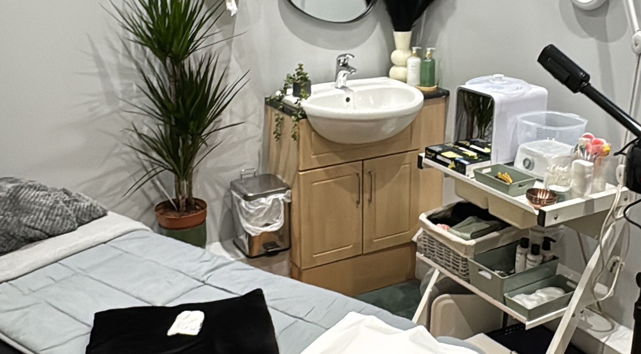 Relaxing treatment room at Botanique, Blairgowrie And Rattray, Scotland with bed, plants, and beauty supplies.