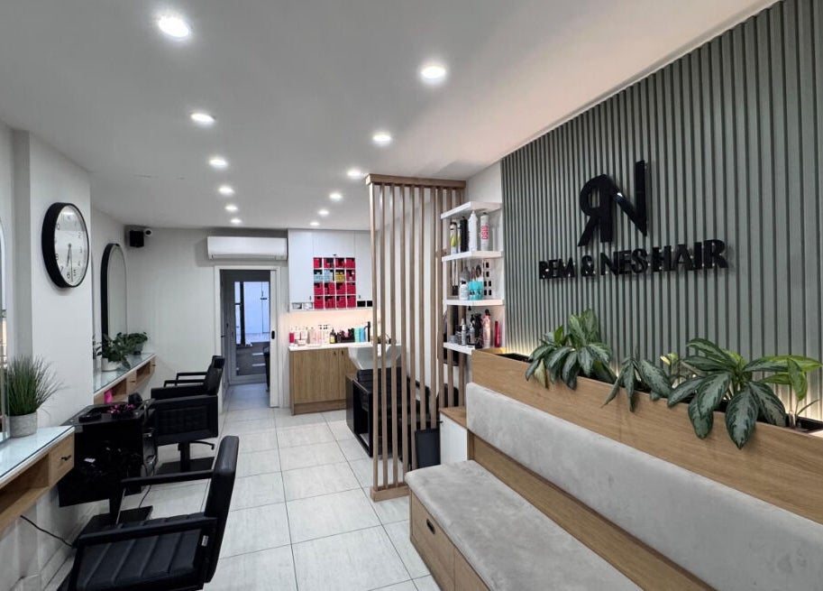 Modern hair salon interior at Rem and Nes, London, England, GB, showcasing stylish design and seating.