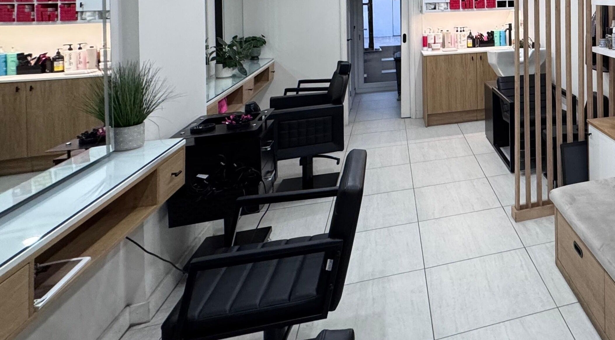 Modern interior of Rem and Nes salon in London, England, GB with sleek black chairs and beauty products.