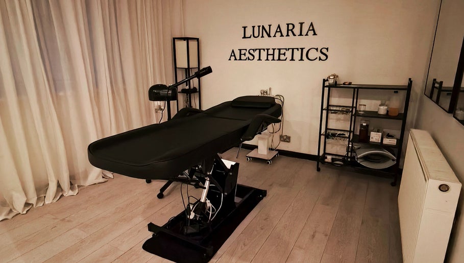 Relaxing treatment room at Lunaria Aesthetics, Nazeing, England, GB, featuring an elegant black treatment table.