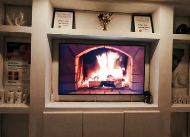 Inviting fireplace at Lunaria Aesthetics, Nazeing, England, GB, surrounded by elegant decor and certificates.
