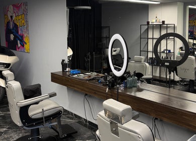 Modern barbershop interior at mmpcutz, Uster, Zürich, CH with white chairs and sleek design.